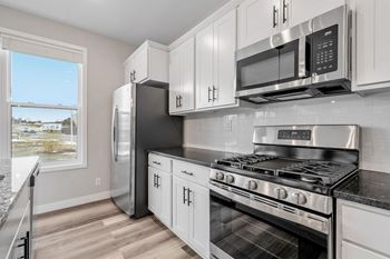 a kitchen with stainless steel appliances and white cabinets